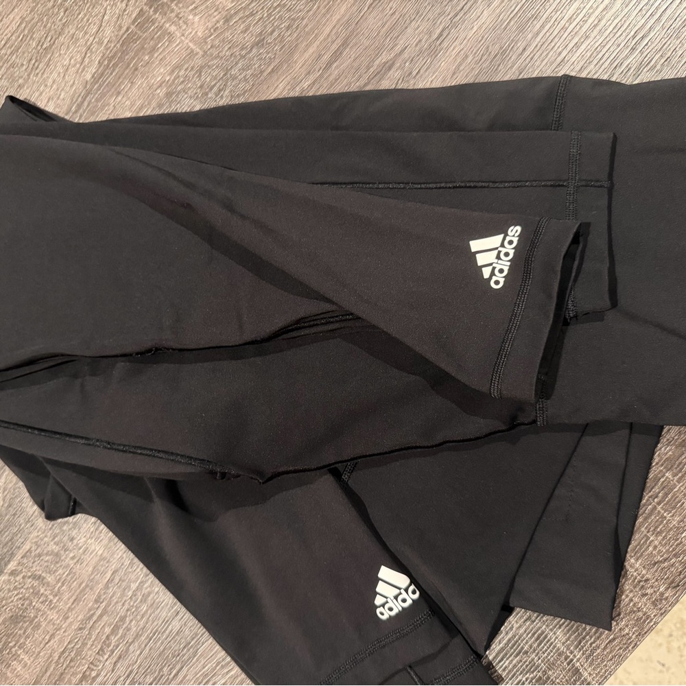 2 pairs of women’s black adidas logo leggings. New without tags, size medium
